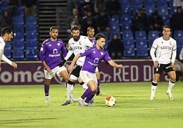 Un futbolista del Guadalajara conduce un balón rodeado de rivales del Ceuta.