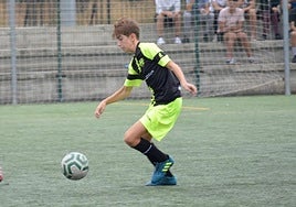 Migue Sierra conduce un balón con el Reino de Granada.