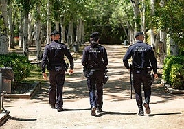 Agentes de la Policía Local de Granada caminando de espaldas.