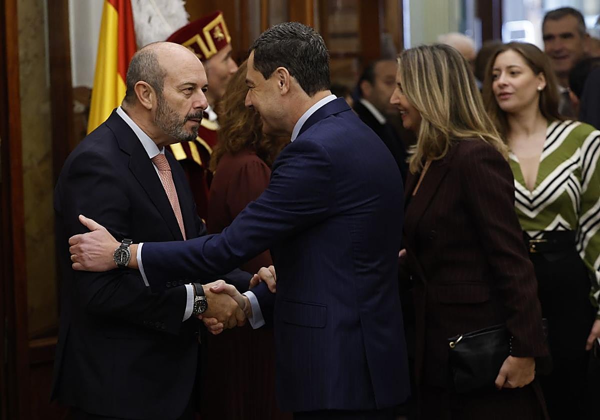 El presidente del Senado, Pedro Rollán, saluda al presidente de la Junta de Andalucía, Juanma Moreno, a su llegada al acto institucional por el Día de la Constitución.