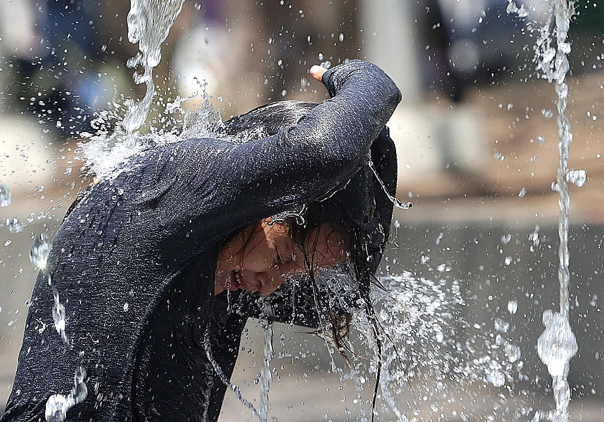 Un joven se refresca ante el calor sofocante