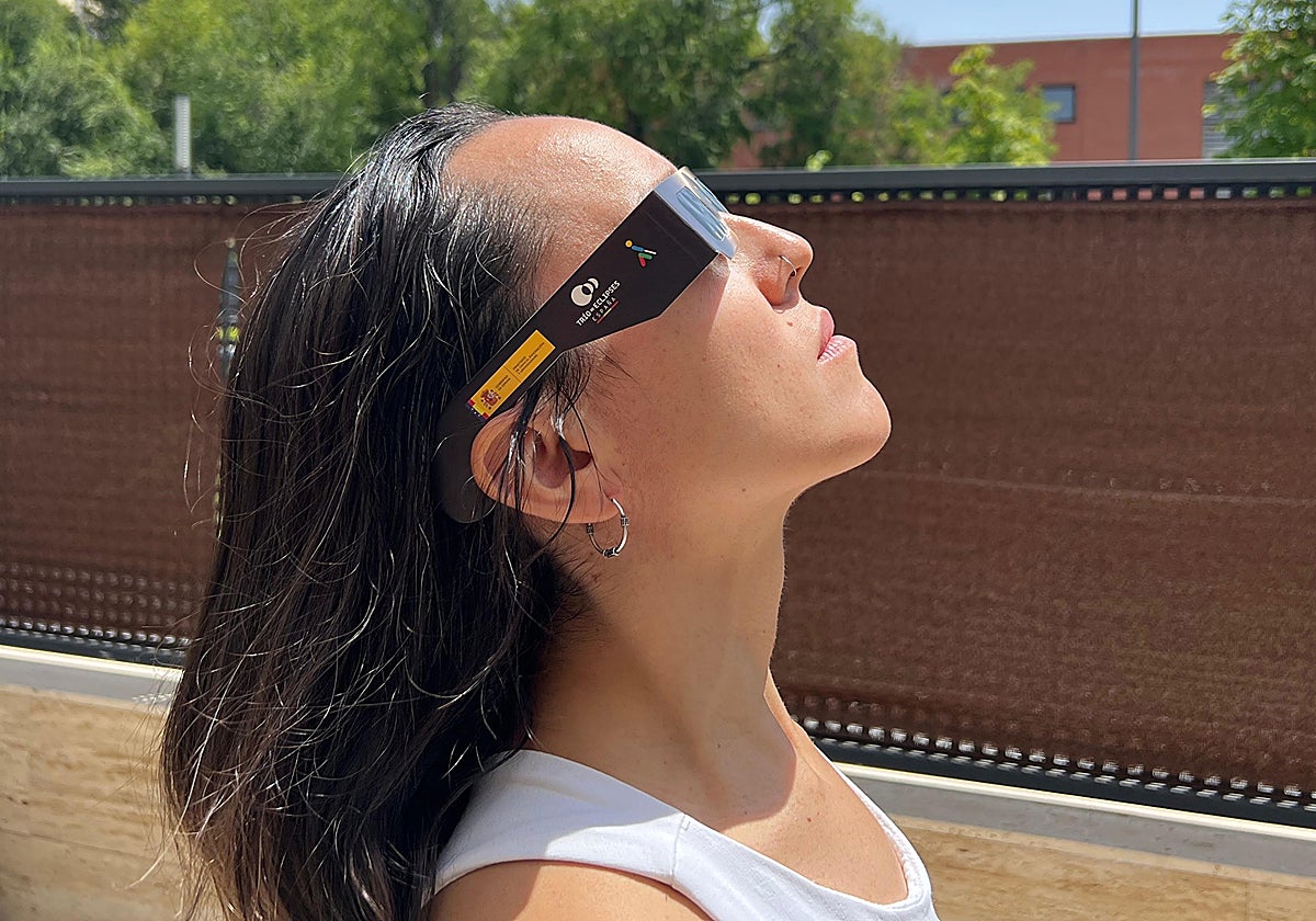 Una usuaria observa el cielo con unas gafas homologadas de la ONCE para observar el eclipse.