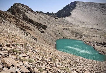 La caldera y su laguna, con el Mulhac&eacute;n (&uacute;ltimo pico por la derecha) como fondo