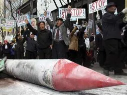 Un grupo de activistas cívicos conservadores participan en una marcha en el centro de Seúl para protestar contra el lanzamiento de un cohete por parte de Corea del Norte. / Efe