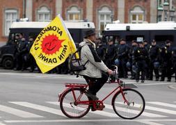 Un activista circula en bici frente a la Policía. / AP