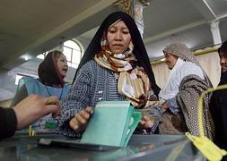 Una mujer afgana emite su voto en un colegio electoral. / Afp