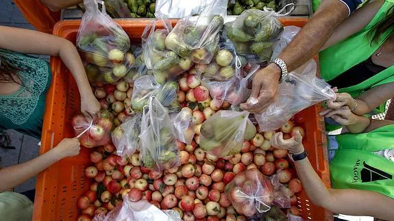 Agricultores repartiendo fruta. 