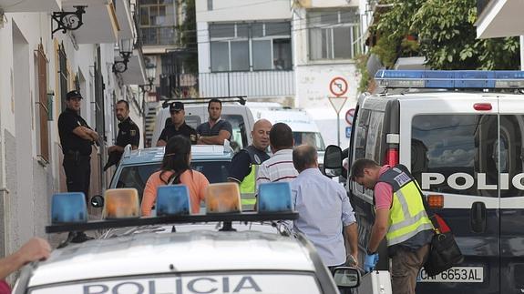 Agentes de la Policía Nacional vigilan la puerta de la vivienda . 