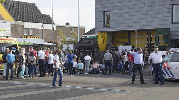 Gente en la escena del accidente delante del automóvil. 