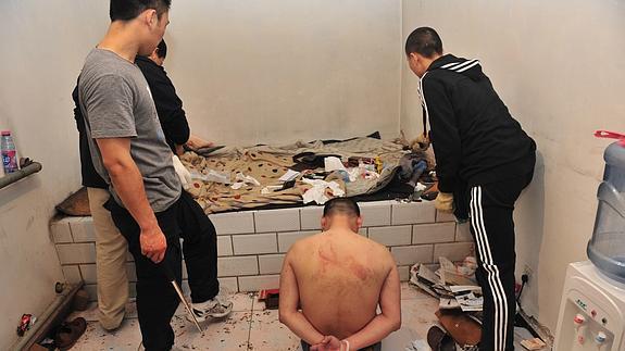 Policías chinos buscan evidencias tras arrestar a un sospecho acusado de tráfico de drogas. 