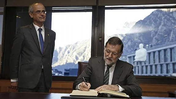 Rajoy firma en el libro de honor en presencia del jefe del Gobierno de Andorra, Antoni Martí. 