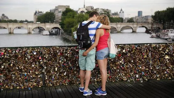 Pareja besándose en el puente Pont des Arts, en París.