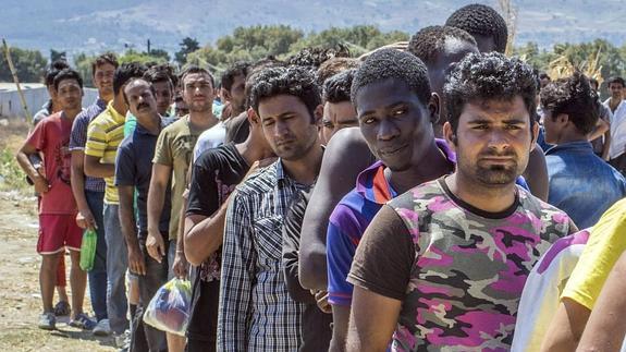 Inmigrantes esperan en fila para recibir comida en la isla de Kos, Grecia.