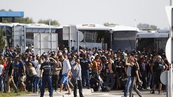 La Policía húngara vigila un grupo de refugiafos en la frontera entre Hungría y Croacia. 