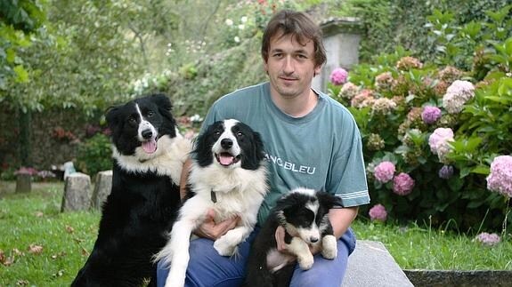 Un criador posa con tres perros 'border collies'.