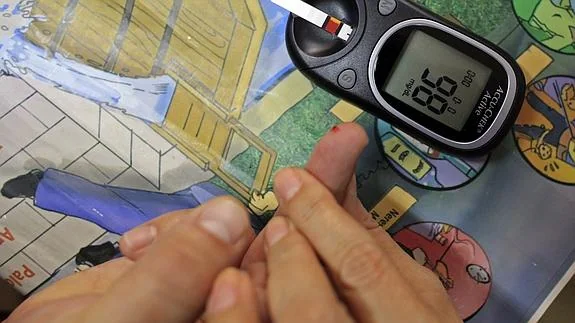 Una doctora muestra cómo hacer la prueba de control de azúcar en sangre a un enfermo de diabetes.