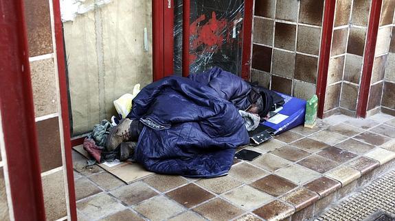 Un sin techo duerme en la calle.
