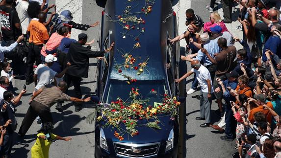 Ciudadanos de Louisville tocan el coche que ha trasladado el féretro de Mohamed Alí.