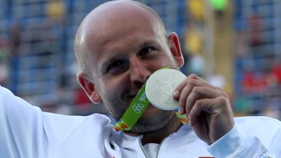 Piotr Malachowski celebra su medalla. 