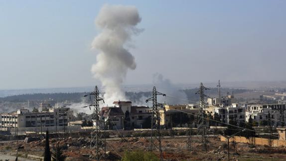 Una columna de humo se eleva durante un ataque aéreo del régimen sirio en Alepo.