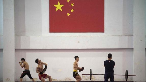 Estudiantes chinos practican artes marciales en la escuela. 