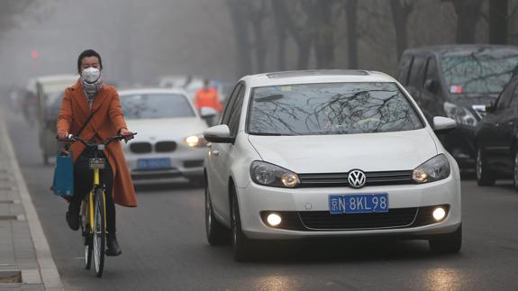 Una mujer con una mascara debido a la bruma por contaminación en Pekín.
