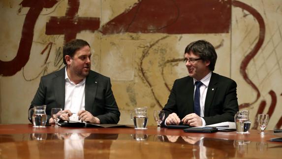 Junqueras (i) y Puigdemont se miran antes de una reunión. 