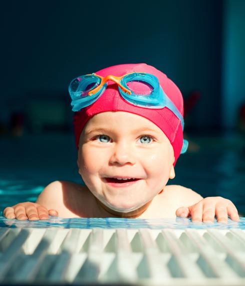 Un niño sonríe en la piscina. 