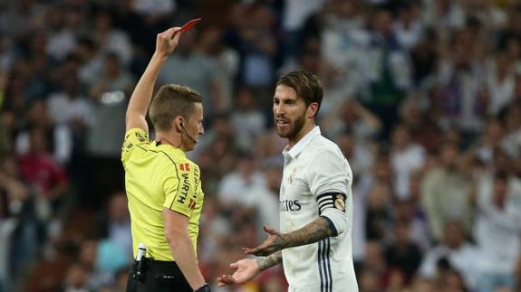 El colegiado Hernández Hernández le muestra la tarjeta roja a Sergio Ramos en el clásico. 