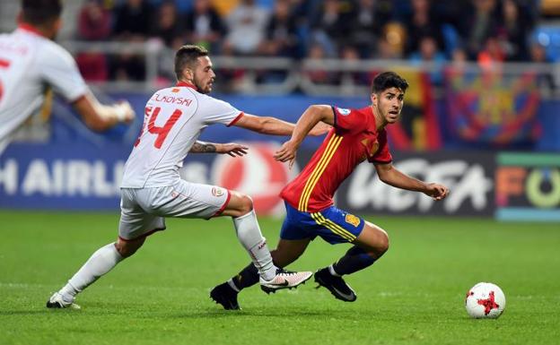 Marco Asensio (d) se escapa de un rival durante el España-Macedonia. 