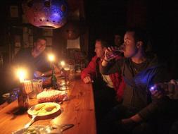 Los clientes de un bar se iluminan con velas durante el corte de luz. GONZÁLEZ MOLERO