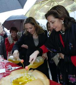 La viceconsejera de Agricultura y la alcaldesa de Martos (derecha), riegan con aceite un hoyo de pan. /F. J. C.