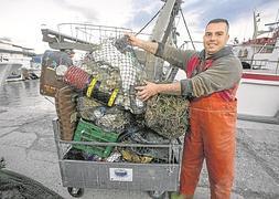 Un marinero con los residuos que han quedado atrapados en las redes de su barco. A partir de ahí se separan y reciclan :: JAVIER MARTÍN