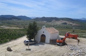 La imagen de la Ermita de San Gregorio, en Oria, y una pala mecánica ilustran el interrogante sobre el futuro de miles de edificios.