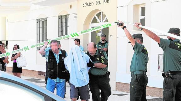 Agentes de la Guardia Civil escoltan al detenido, de 41 años, a la salida de la urbanización donde ocurrió el crimen.