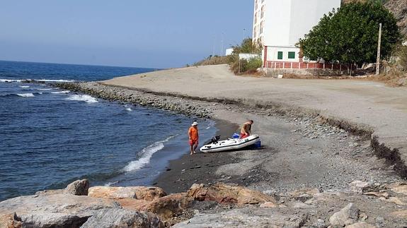 Dos hombres desembarcan en una de las pequeñas zonas con arena.
