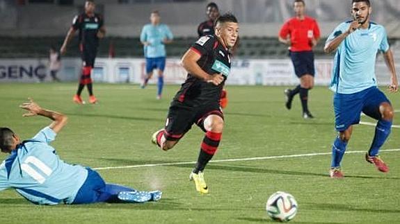 Bravo, jugador del Granada B, supera a un defensa del Lucena con velocidad y habilidad.