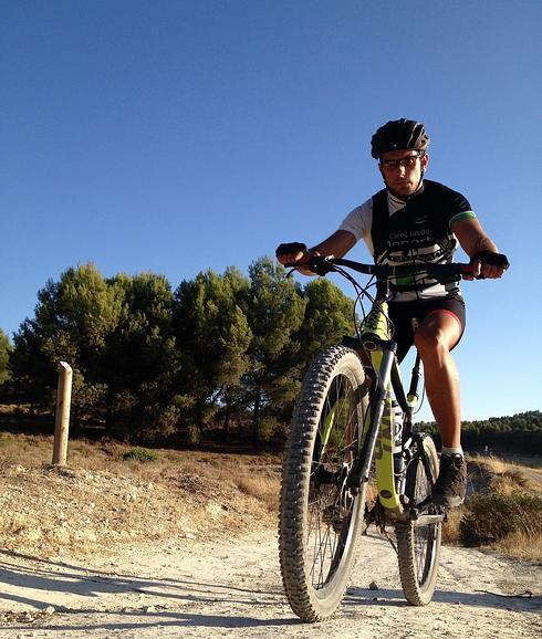 Ciclista con la Dehesa de Santa Fe al fondo.