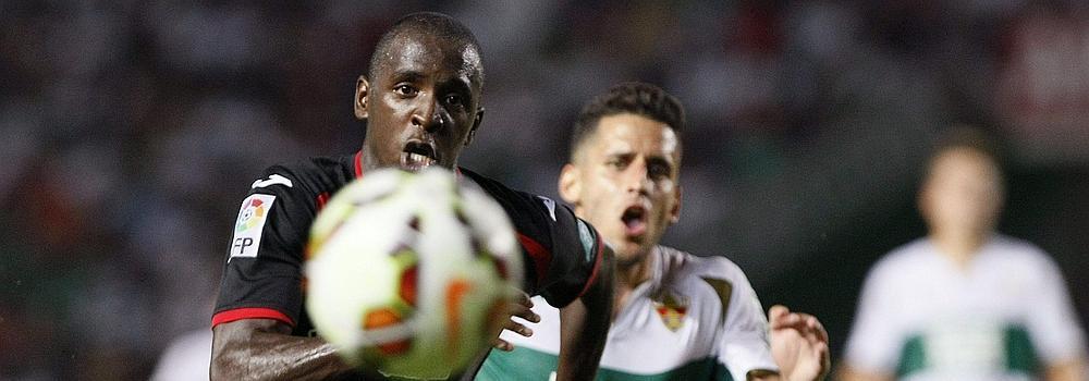 El centrocampista del Elche Ferrán Corominas corre tras el balón con el francés Abdoul Sissoko, del Granada.