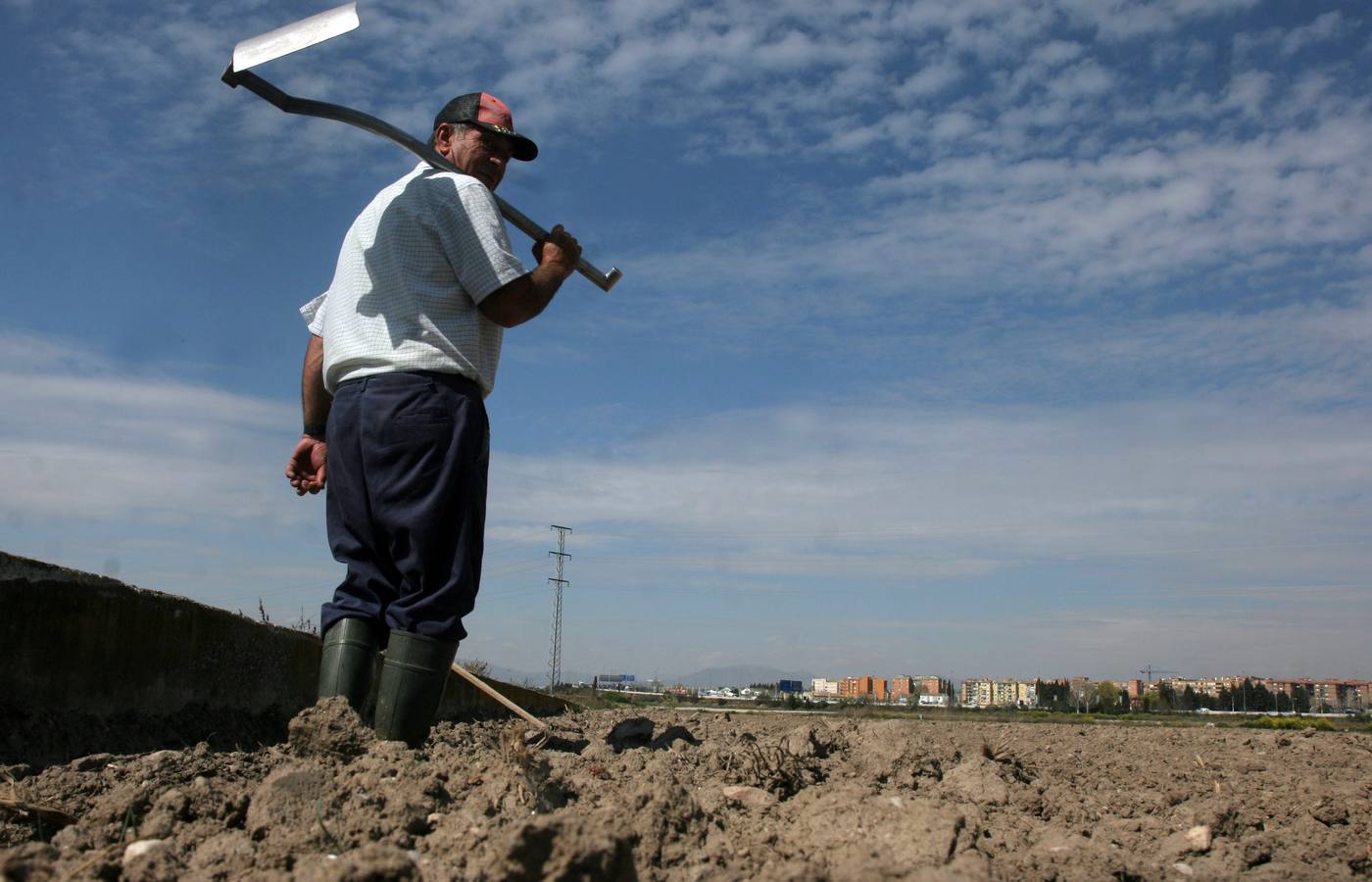 Un agricultor contempla la tierra seca por la falta de lluvias en un campo cercano a Granada.