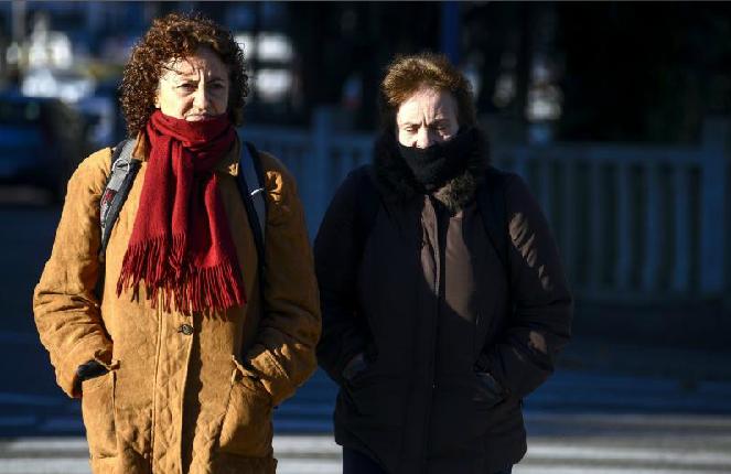 Dos mujeres se protegen del frío 