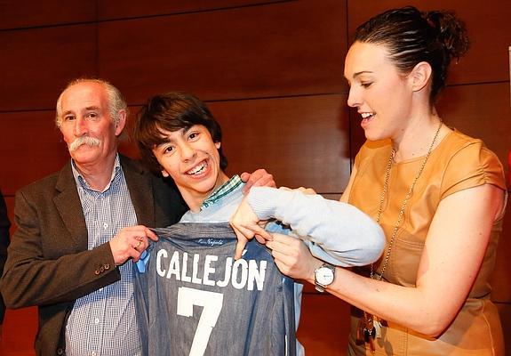 El padre del futbolista Callejón le entrega una camiseta de su hijo a uno de los deportistas discapacitados de ASPACE.