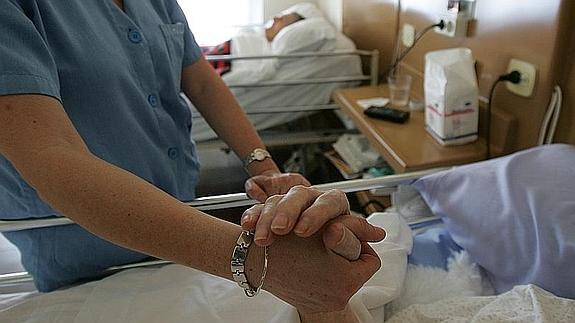 Una enfermera conforta a una paciente ingresada en una clínica para ancianos 
