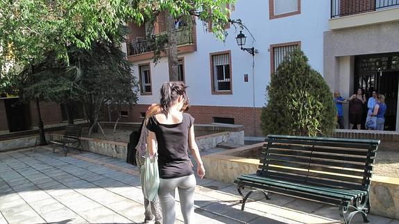 Dos vecinas señalan el lugar donde ha aparecido el cadáver en la Plaza de la Cruz de La Zubia.