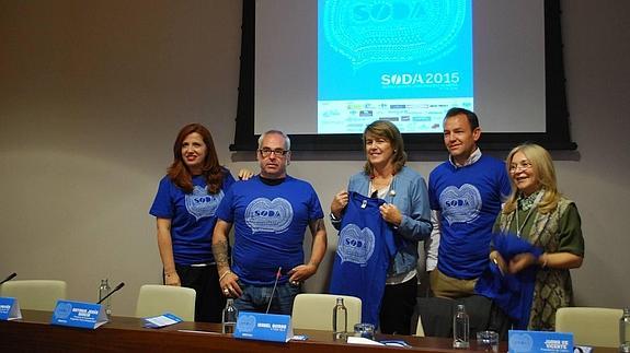 Los organizadores muestran las camisetas de la cita.