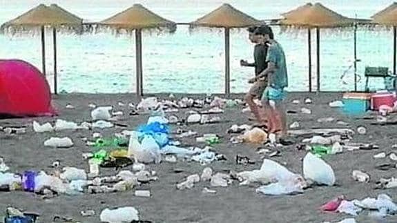 Estado de la playa Puerta del Mar, en Almuñécar, a primera hora de la mañana de ayer tras la conclusión de la noche de San Juan, que dejó toneladas de basura en la arena