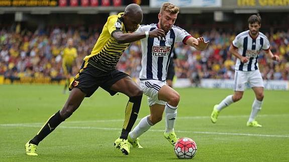 El lateral Allan Nyom (i) se esfuerza en recuperar la pelota en un partido del Watford.