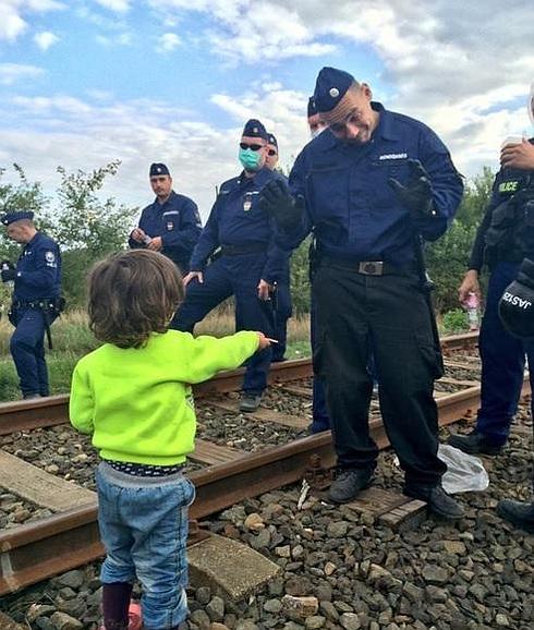 La foto que enternece al mundo: un niño refugiado sirio 'desarma' a un policía ofreciéndole una galleta