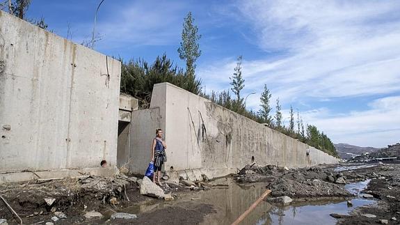 Laima llora junto a la entrada del desagüe en el que vivía con Stepa, Darius y Nicolai, los tres fallecidos por la riada del pasado lunes que afectó a la rambla de Albuñol.