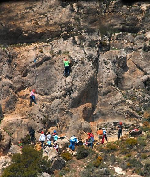 Grupos de escaladores, profesores y alumnos, llenan las paredes situadas en los accesos a la Alfaguara. 